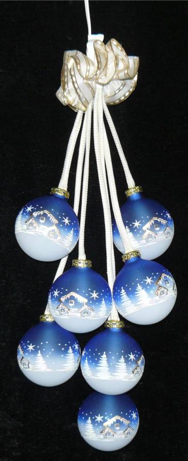 Glaskugelschmuck mit blauen Kugeln und weissem Landhausmotiv. beleuchtet